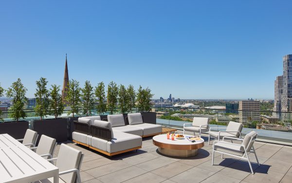 Spacious penthouse outdoor terrace with lounge furniture overlooking Melbourne CBD
